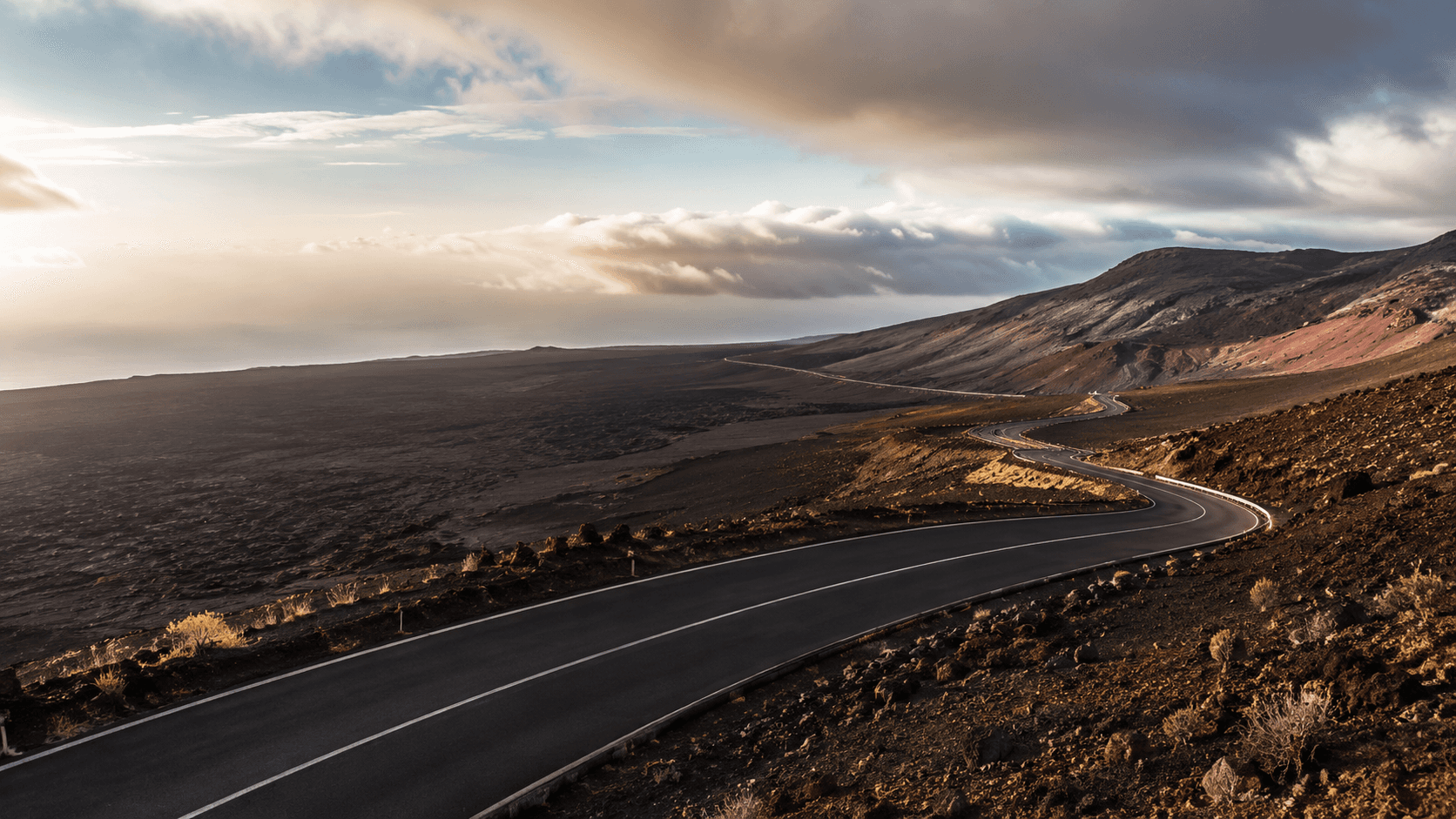 Route sinueuse menant au Piton de la Fournaise dans un paysage volcanique de La Réunion